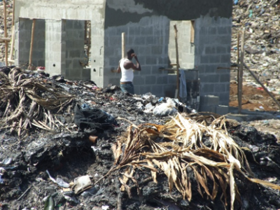 A man walking past a heap of garbage