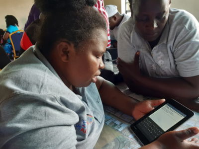Woman on tablet during CHV mapping of Mukuru