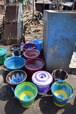 Buckets of water to be carried by resident women and girls to their homes