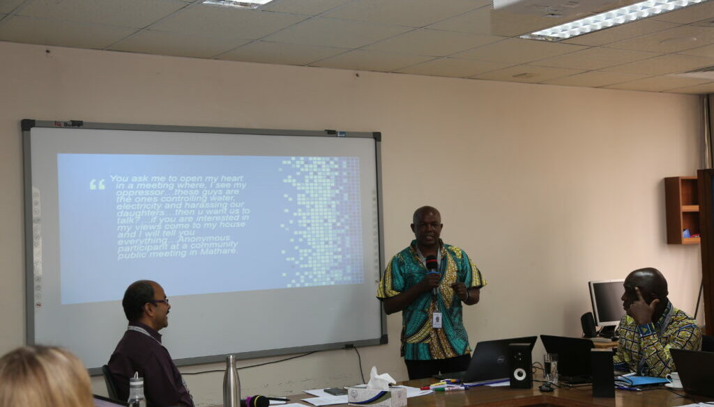 Kimani presenting in front of a slide with the quote from the blog on it