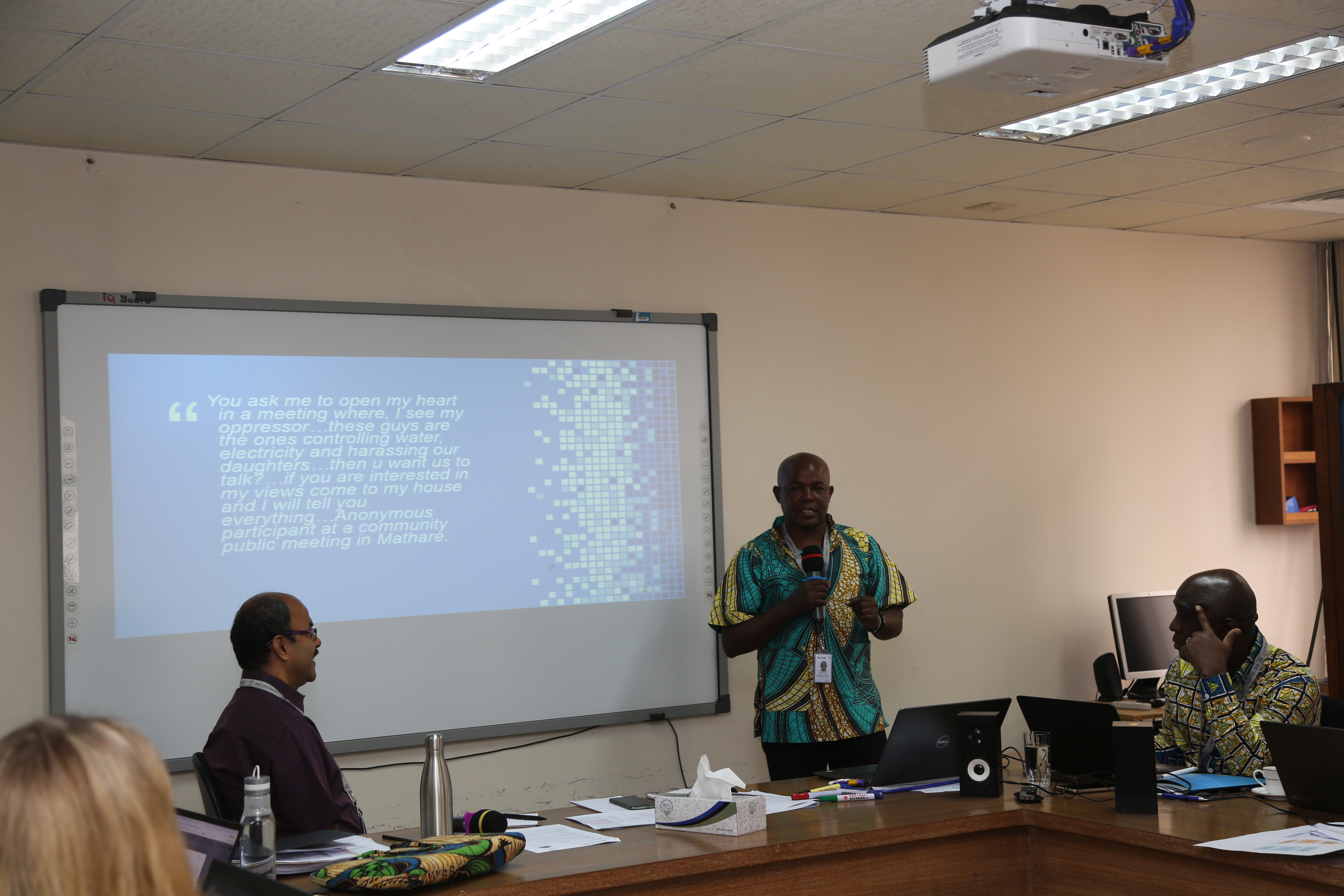 Kimani presenting in front of a slide with the quote from the blog on it