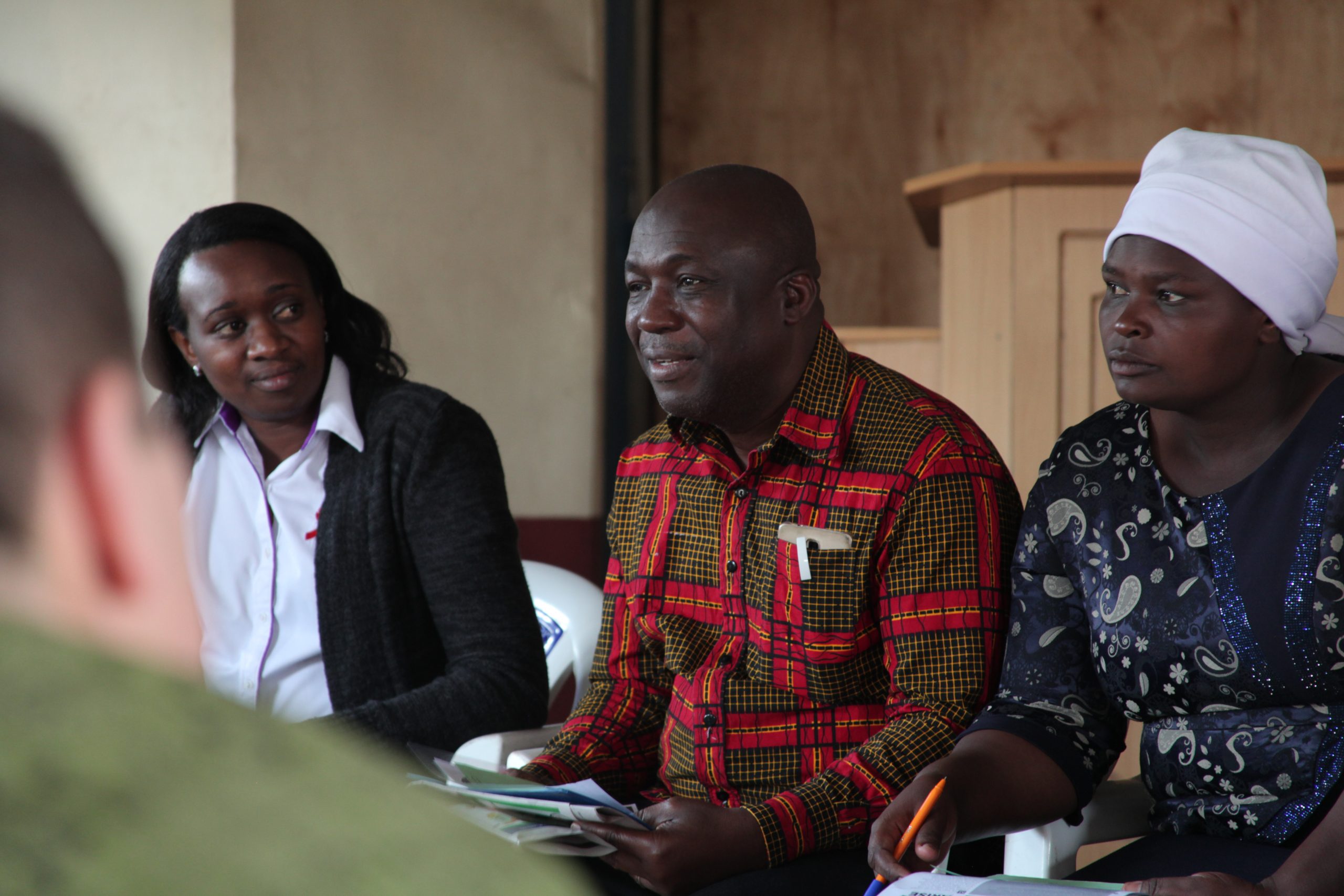 Lilian of LVCT Health and Blessing of APHRC with a member of the community during a group assignment in Kenya