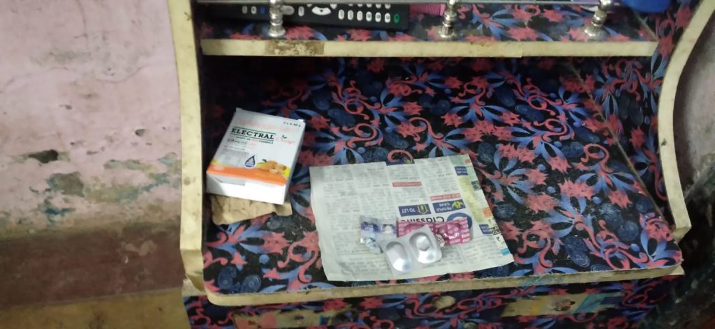 Tablets, electrolyte powder and newspaper on side table in room