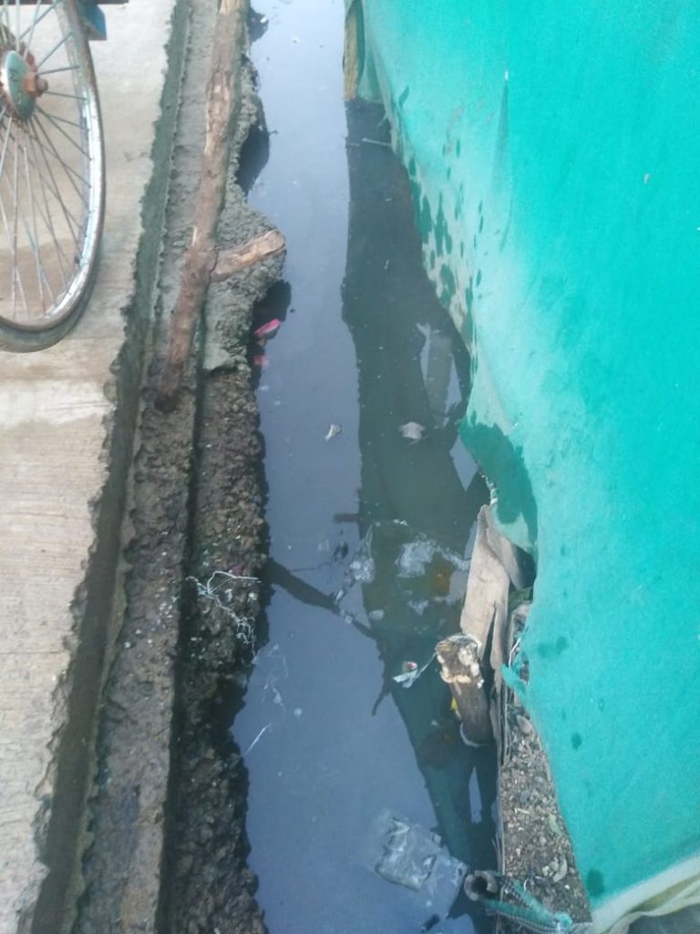 Drainage canal with blue tarpaulin on right hand side