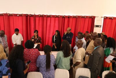 ARISE colleagues stand in front of a red curtain at AGM during a reflections feedback session